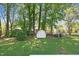 View of the spacious, green backyard featuring a storage shed surrounded by mature trees at 2311 Wintergreen Pl, Durham, NC 27707