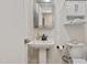 Bright bathroom featuring white pedestal sink, matching toilet, and modern silver framed mirror at 2311 Wintergreen Pl, Durham, NC 27707