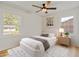 Cozy bedroom with a ceiling fan and a comfortable bed, illuminated by natural light from two windows at 2311 Wintergreen Pl, Durham, NC 27707