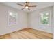 Bright bedroom with hardwood floors, a ceiling fan, and two windows at 2311 Wintergreen Pl, Durham, NC 27707