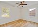 Well-lit bedroom with hardwood floors, two bright windows, and a modern ceiling fan at 2311 Wintergreen Pl, Durham, NC 27707