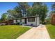 Exterior view of a freshly painted home with a long driveway and manicured lawn at 2311 Wintergreen Pl, Durham, NC 27707