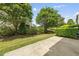 Well-maintained backyard with lush lawn, mature trees, and concrete patio at 245 Kylemore Cir, Cary, NC 27513