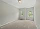 Neutral bedroom features wall-to-wall carpet, light grey walls, and two windows for natural light at 245 Kylemore Cir, Cary, NC 27513