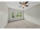Well lit bedroom with neutral walls and carpet, complemented by multiple windows offering views of the greenery outdoors at 245 Kylemore Cir, Cary, NC 27513