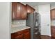 Kitchen featuring stainless steel refrigerator and a granite countertop with matching cabinets at 245 Kylemore Cir, Cary, NC 27513