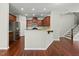 Modern kitchen featuring stainless steel appliances, granite countertops, and dark wood cabinetry at 245 Kylemore Cir, Cary, NC 27513