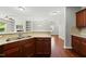 Beautiful kitchen features granite counters, stainless sink, and dark wood cabinets with stylish tile backsplash at 245 Kylemore Cir, Cary, NC 27513