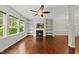 Living room featuring a fireplace with built-in shelves, hardwood floors and three windows that offer great natural light at 245 Kylemore Cir, Cary, NC 27513