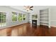 Bright living room with hardwood floors, fireplace, and built-in shelving offering cozy charm and outdoor views at 245 Kylemore Cir, Cary, NC 27513