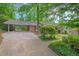 Charming brick home with a carport and a well-maintained lawn, surrounded by lush greenery at 2508 Sevier St, Durham, NC 27705