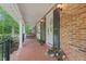 Inviting brick front porch with swing, potted plants and brick floor at 2508 Sevier St, Durham, NC 27705