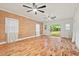 Bright, spacious room with hardwood floors, wooden accent wall, and sliding glass doors to outside at 2508 Sevier St, Durham, NC 27705