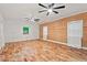Bright, spacious room with hardwood floors, natural wood accent wall, and modern ceiling fans at 2508 Sevier St, Durham, NC 27705