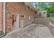 A brick house features a stone patio with retaining wall and chain link fence at 2508 Sevier St, Durham, NC 27705
