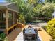 Spacious backyard with a wooden deck, outdoor seating, and a charming screened porch with string lights at 2529 Remington Rd, Raleigh, NC 27610