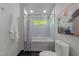 Bathroom featuring a tub/shower combination, tiled walls, and a window for natural light at 2529 Remington Rd, Raleigh, NC 27610