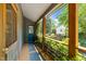 Inviting screened porch with wood railings, lush greenery, and a view of the front yard at 2529 Remington Rd, Raleigh, NC 27610