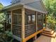 Beautiful screened porch with wood and metal railings, steps to a wooden deck, and brick pier foundation at 2529 Remington Rd, Raleigh, NC 27610