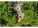 An aerial view of a charming home surrounded by lush greenery, featuring a patio, fire pit, and rooftop deck at 2613 Bedford Ave, Raleigh, NC 27607