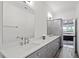 Bathroom featuring a double vanity, grey cabinetry, and an adjoining room at 2613 Bedford Ave, Raleigh, NC 27607