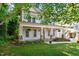 Inviting two-story home with a cozy front porch, green lawn, and mature trees at 2613 Bedford Ave, Raleigh, NC 27607
