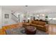 Spacious living room with hardwood floors, a cozy couch, and an open kitchen area at 2613 Bedford Ave, Raleigh, NC 27607