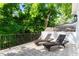Outdoor patio with two lounge chairs, patterned tile flooring, and a view of lush greenery at 2613 Bedford Ave, Raleigh, NC 27607