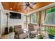 Relaxing sunroom with wood ceilings, comfortable furniture, and large screened windows at 2613 Bedford Ave, Raleigh, NC 27607