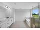 Bathroom featuring double vanities, a separate bathtub, and a frameless glass shower at 2625 Stonington Dr, Cary, NC 27523