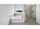 Bright bathroom featuring a soaking tub, walk-in shower with glass door, and a large window at 2625 Stonington Dr, Cary, NC 27523