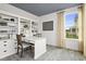 Bright home office with custom built-in shelving, sleek white desk, and a large window offering natural light at 264 Alden Way, Angier, NC 27501