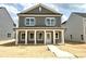 Charming two-story home featuring gray siding, white trim, and a welcoming front porch with classic columns at 2868 Quarry Rd # 167, Rolesville, NC 27571