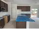 Spacious kitchen with dark brown cabinets and a large central island, partially covered in protective blue film at 2868 Quarry Rd # 167, Rolesville, NC 27571