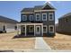 New construction two story home featuring gray siding, white trim, and covered porch at 2872 Quarry Rd # 166, Rolesville, NC 27571