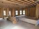 Unfinished living room features framed walls, windows, and a doorway, showcasing construction progress at 2872 Quarry Rd # 166, Rolesville, NC 27571