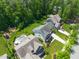 Gorgeous aerial view of a home with a backyard pool, green grass, and neighboring homes surrounded by mature trees at 2993 Club Dr, Raleigh, NC 27613