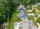 Beautiful aerial view of luxury home with a backyard pool and well-manicured lawn surrounded by mature trees at 2993 Club Dr, Raleigh, NC 27613