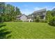 Expansive backyard featuring a lush lawn, mature trees, and a charming patio area at 2993 Club Dr, Raleigh, NC 27613