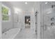 Bright bathroom featuring marble floors, glass shower, soaking tub, and dual sink vanity at 2993 Club Dr, Raleigh, NC 27613