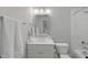 Bright bathroom boasts a sleek vanity with a framed mirror, modern fixtures, and tiled shower and tub combination at 2993 Club Dr, Raleigh, NC 27613