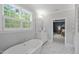 Light filled bathroom with shuttered windows, marble floors, soaking tub, and vanity at 2993 Club Dr, Raleigh, NC 27613