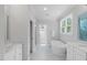 Bright bathroom featuring a soaking tub, glass shower, marble countertop, and ample natural light at 2993 Club Dr, Raleigh, NC 27613