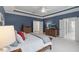 Bedroom with tray ceiling, blue walls, neutral decor and an open doorway to an adjacent room at 2993 Club Dr, Raleigh, NC 27613