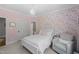 Bedroom featuring floral wallpaper, white furniture, grey chair, and a chandelier at 2993 Club Dr, Raleigh, NC 27613