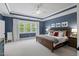 Bedroom with tray ceiling, natural light, and neutral decor; providing a serene and calming space at 2993 Club Dr, Raleigh, NC 27613