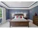 Bedroom with a tray ceiling, large windows, and wood furniture offering a comfortable space at 2993 Club Dr, Raleigh, NC 27613