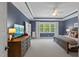 Spacious bedroom with a tray ceiling, blue walls, and a large window offering ample natural light at 2993 Club Dr, Raleigh, NC 27613