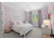 Charming bedroom featuring floral wallpaper, white bed frame, and accent pillows at 2993 Club Dr, Raleigh, NC 27613