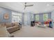 Spacious bonus room with blue walls, ceiling fan, comfortable seating and built-in window seats at 2993 Club Dr, Raleigh, NC 27613